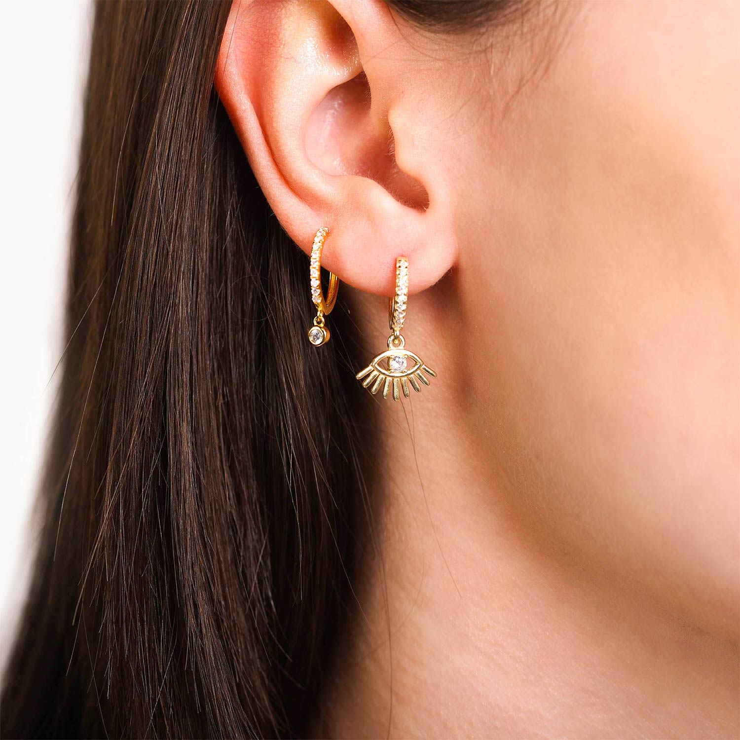 Female Model Wearing Layered Gold Evil Eye Huggie Hoop Earrings Kai - Playa Luna Jewelry